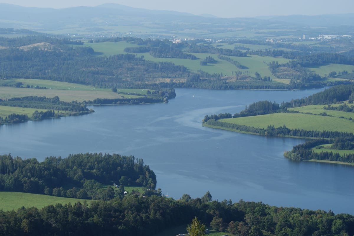 Přehrada Slezská Harta z výšky, zelené louky a lesy kolem vodní hladiny